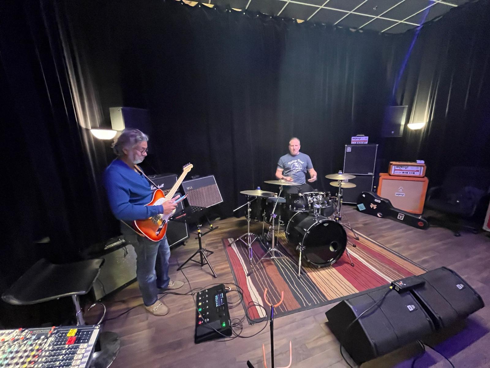 two band members warming up in a rehearsal room